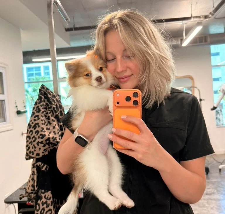 Valeriia hugging a Pomeranian puppy in the salon